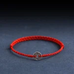 Five Emperor Coins red string bracelet front view with silver coin charm on braided red cord