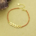 Five-Emperor Coins Red String Sterling Silver Bracelet - Top-Down Flat Lay View with Gold Charms