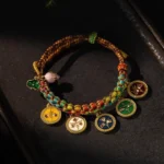 Five God of Wealth Tibetan multicolor braided rope bracelet with enamel pendants - top down flat lay