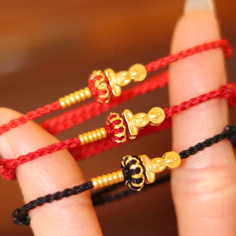 Formless Buddha red string protection bracelet worn on hand with gold beads and black accent strings