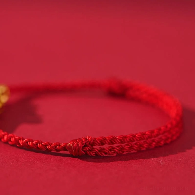Minimalist red woven string bracelet with flat knot closure showing braided texture