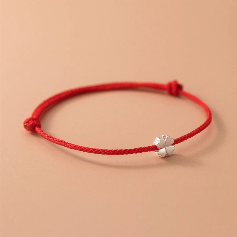 polished silver four leaf clover charm on red braided cord with adjustable knots