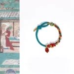 Four-strand braided red string bracelet with natural red agate Pixiu pendant flat lay