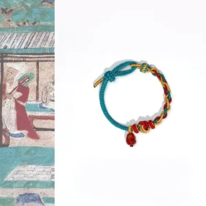 Four-strand braided red string bracelet with natural red agate Pixiu pendant flat lay