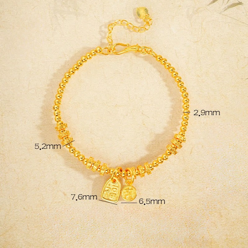 Flat lay top-down view of gold Fu charm bracelet with dimension measurements and twisted bead chain