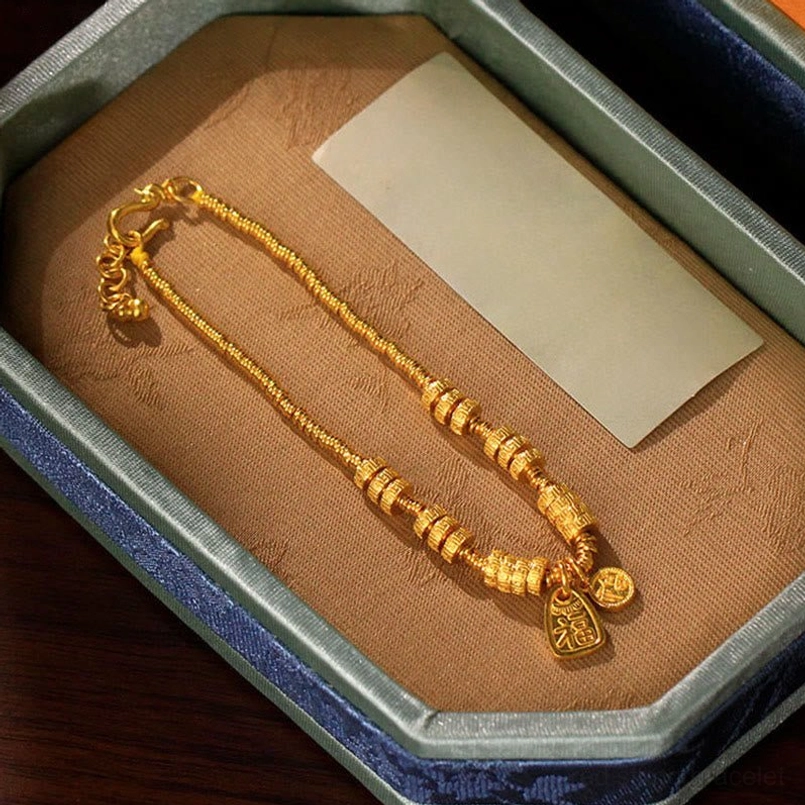 Gold Fu character blessing bracelet displayed in jewelry gift box with cleaning cloth