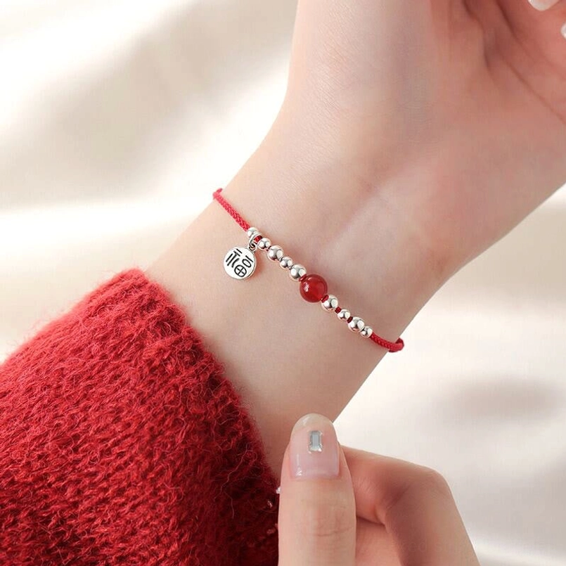 Red agate fortune bracelet worn on wrist with sweater showing authentic fit