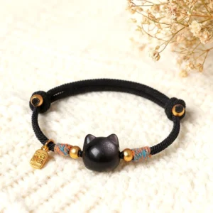 Silver Sheen Obsidian cat protection bracelet with Fu character charm on knitted blanket with dried flowers