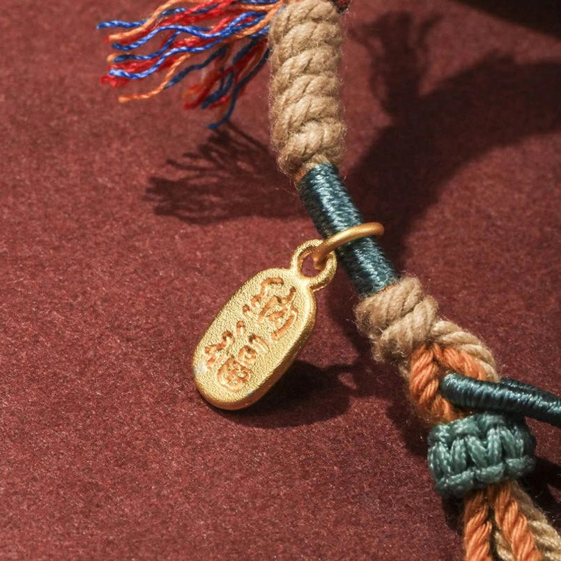 Extreme close up of braided multicolor rope and Chinese Fu character charm