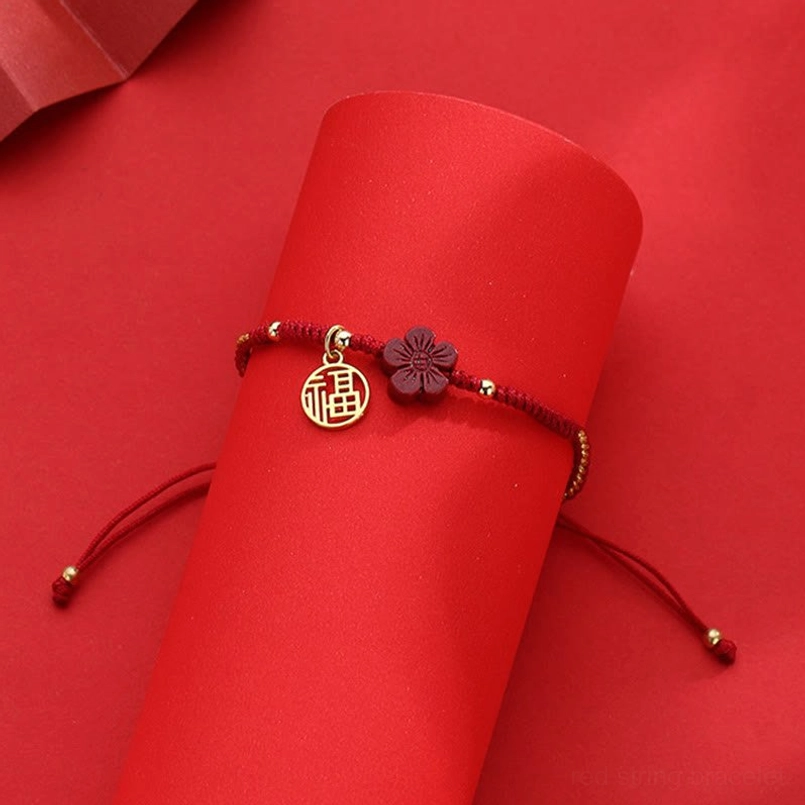 Fortune braided red string bracelet displayed on stand with Fu pendant