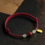 Flat lay view of Fu Character Hetian jade cinnabar red string prosperity bracelet