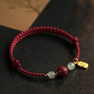 Flat lay view of Fu Character Hetian jade cinnabar red string prosperity bracelet