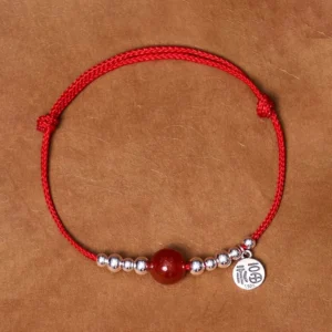 Handmade 925 sterling silver Fu character red agate fortune bracelet flat lay on kraft paper