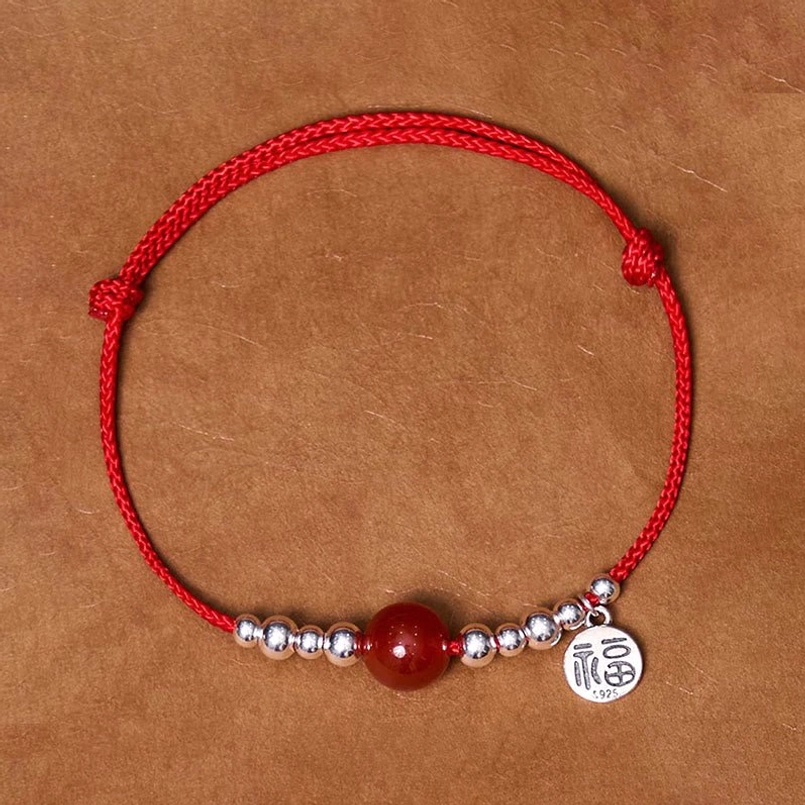 Handmade 925 sterling silver Fu character red agate fortune bracelet flat lay on kraft paper