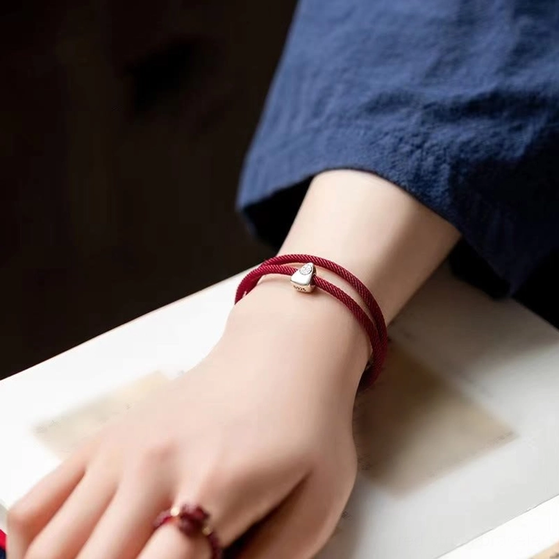 Red string sterling silver fu bracelet worn on woman's wrist daily wear