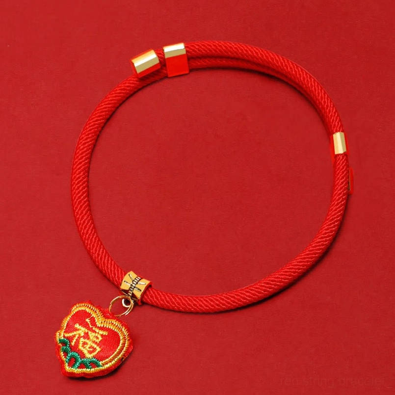 Fu character red string pet collar close-up showing gold beads and blessing pendant