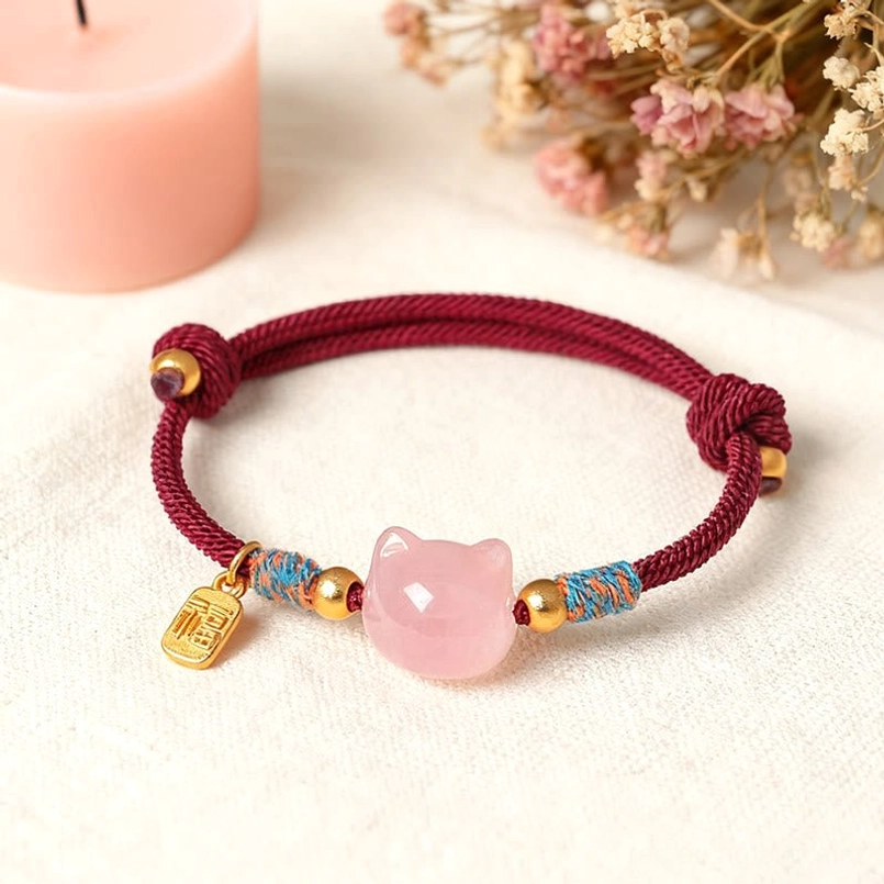Close-up detail of fu charm pendant and cat bead on handmade protection bracelet