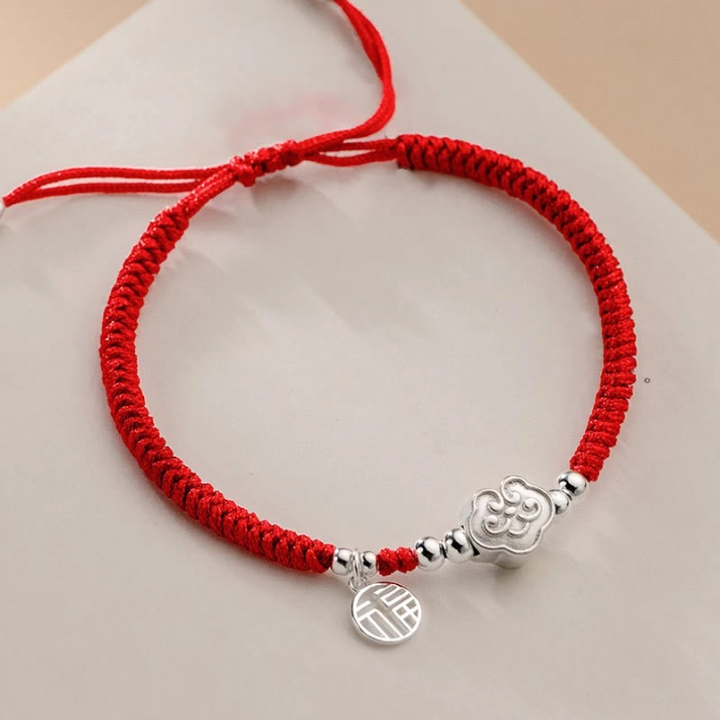 Flat lay view of full braided red lucky bracelet with 925 silver Fu and cloud charms