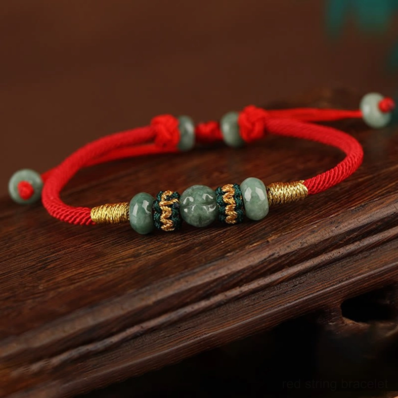 Full loop jade abacus red string bracelet flat lay on dark wood tabletop