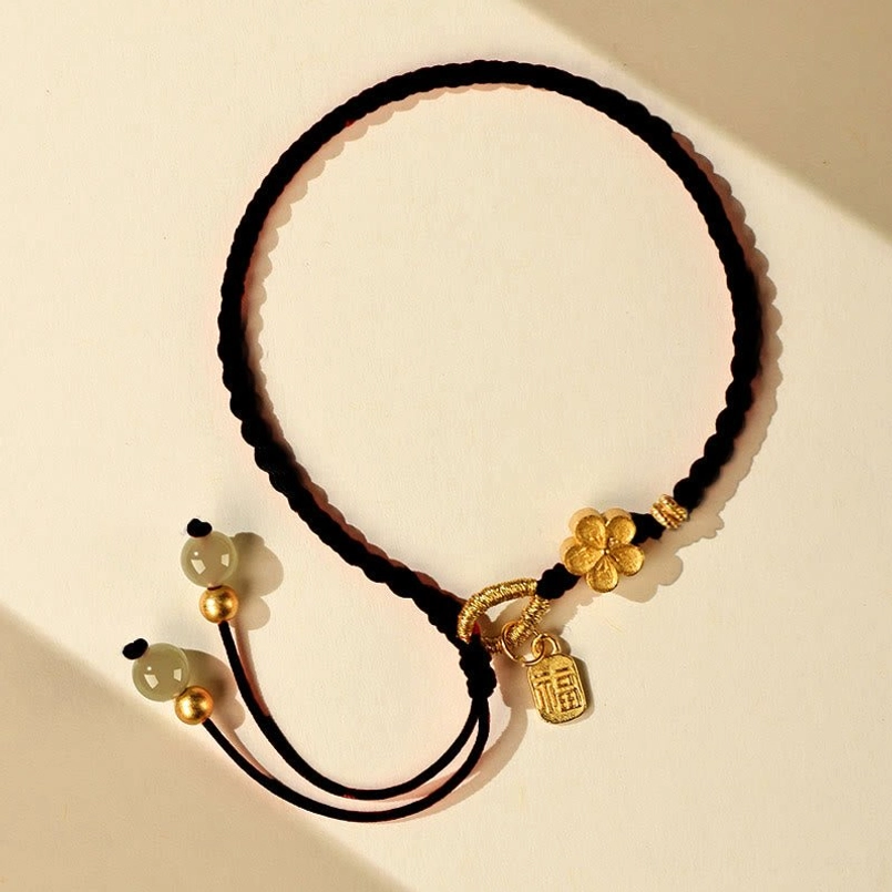 Full display of black Hetian jade red string bracelet on light background