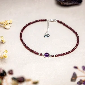 Garnet amethyst red string anklet flat lay with dried flowers and crystal props