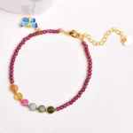 Garnet tourmaline butterfly bracelet and anklet with blue enamel charm on light background