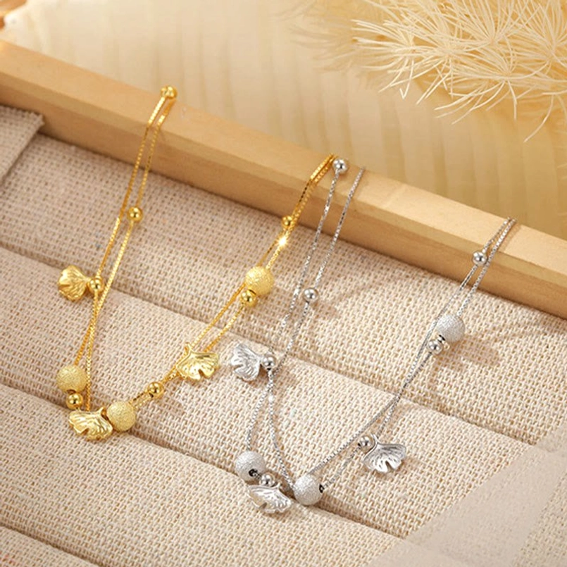 Gold and silver ginkgo leaf double layer anklets flat lay display comparison