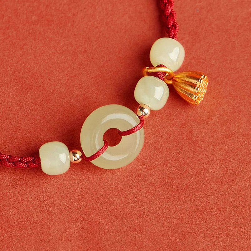 Detailed view of textured gold lotus pod and jade peace buckle