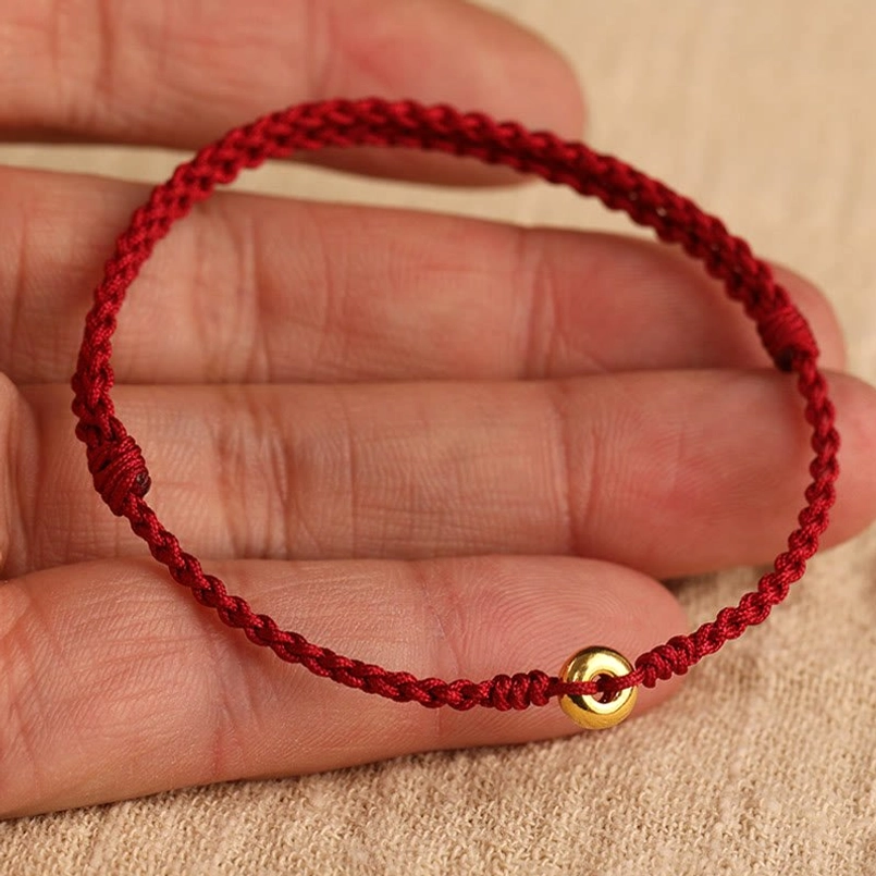 999 gold peace buckle red string bracelet product shot with charm focus