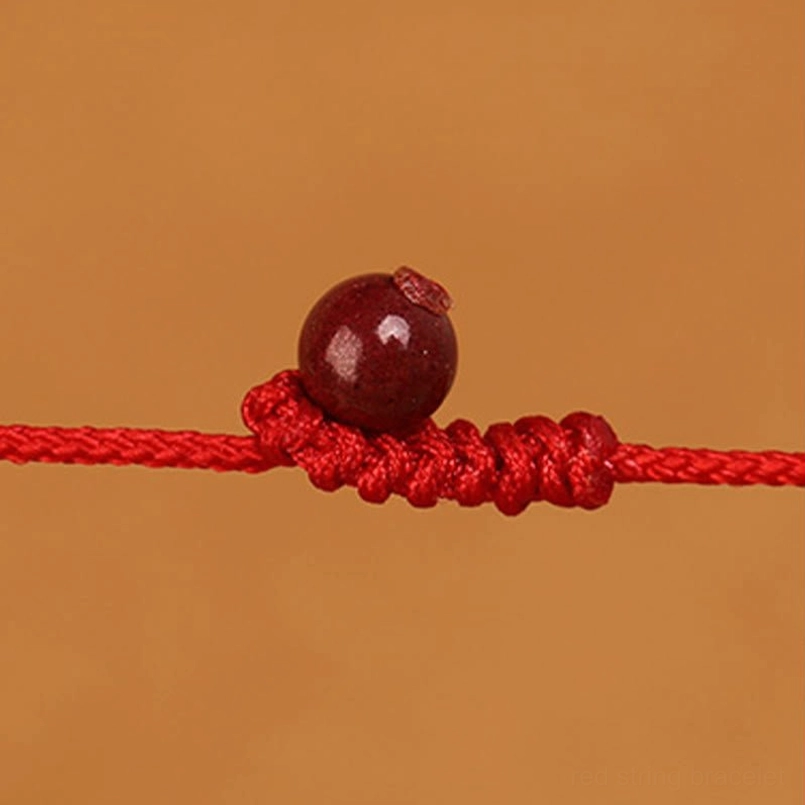 Red string belly chain with zodiac charm worn during casual daily styling and outfit matching