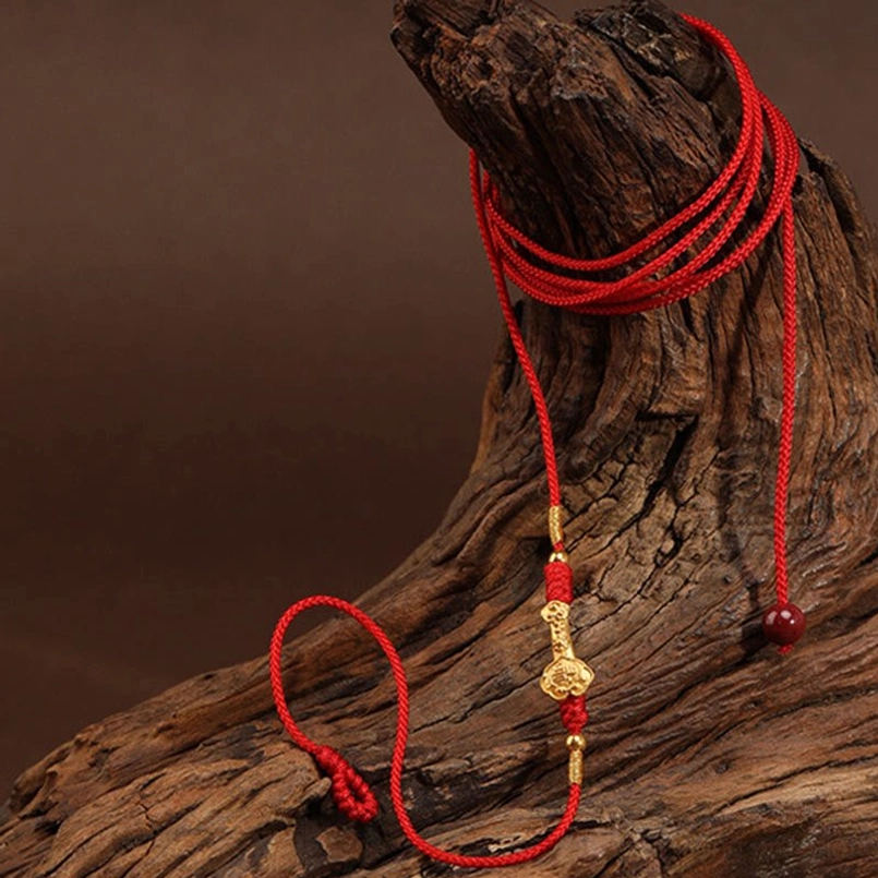 Hanging product display of 999 gold red string belly chain on wooden stand with red bead clasp