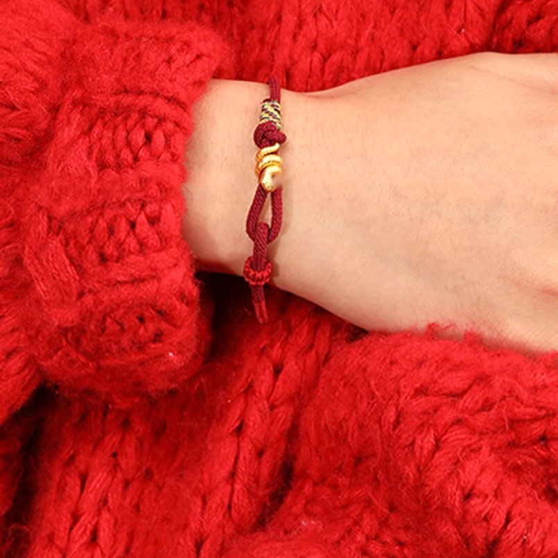 adjustable sliding knot detail of gold snake red string bracelet on wrist