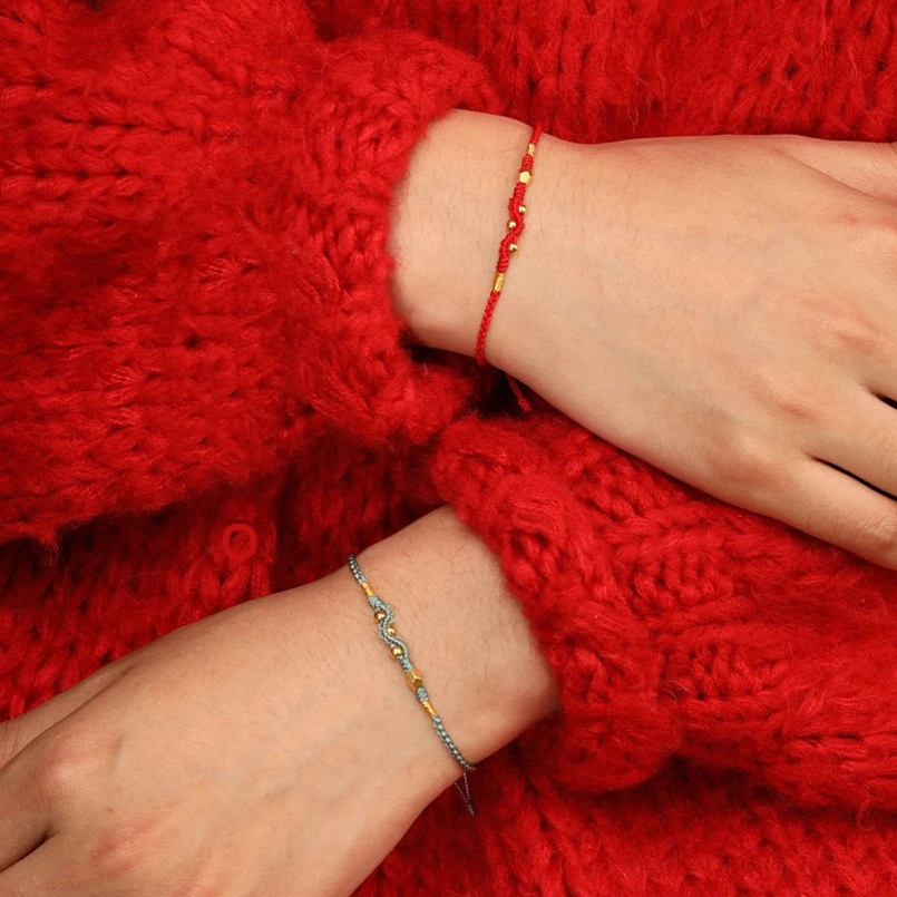 Year of the snake red string bracelet worn on hand with casual outfit