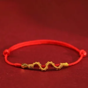 999 gold snake red string braided bracelet with wavy gold weave and metal beads on dark background