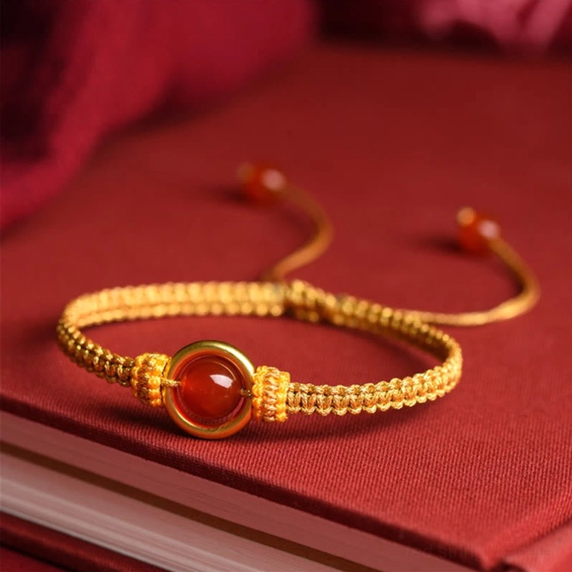 Golden Woven Red Agate Peace Buckle Bracelet Flat Lay On Vintage Red Book