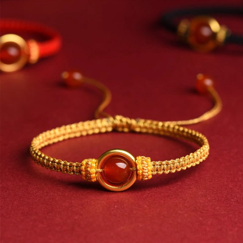 Golden Braided Rope Red Agate Peace Buckle Bracelet Close Up On Red Fabric