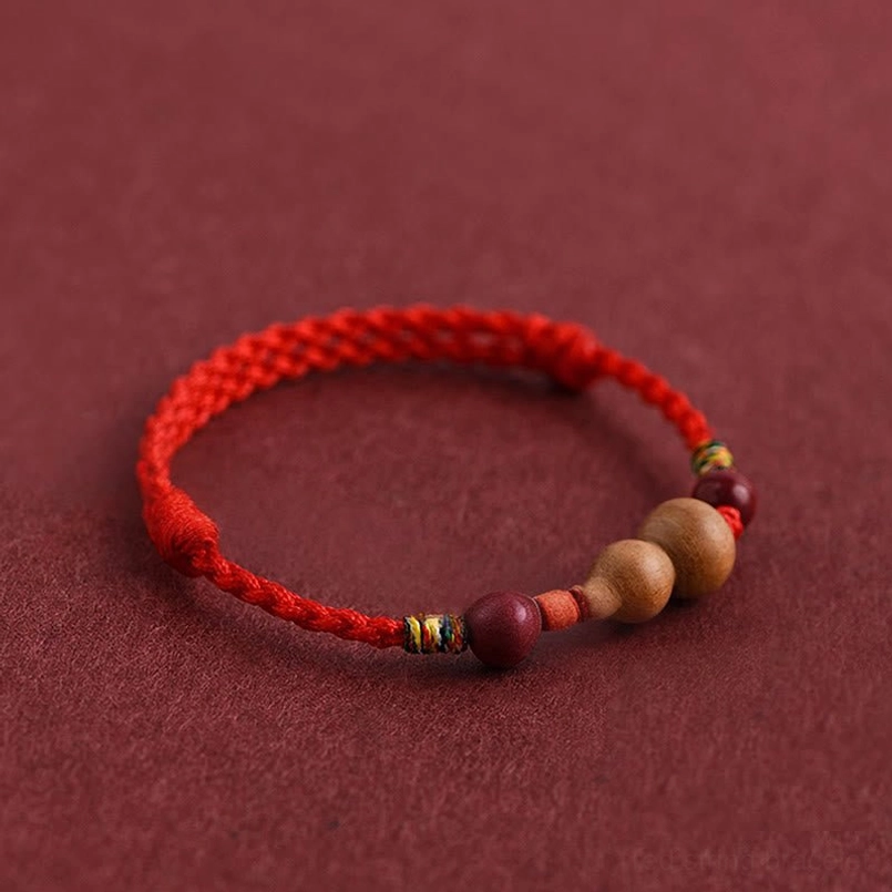 Peach wood gourd bracelet reversed angle view showing wooden charm and red rope design