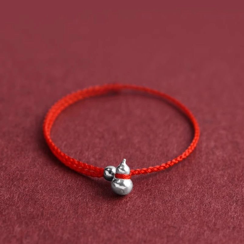 handmade red string bracelet with silver gourd charm and spacer bead detail