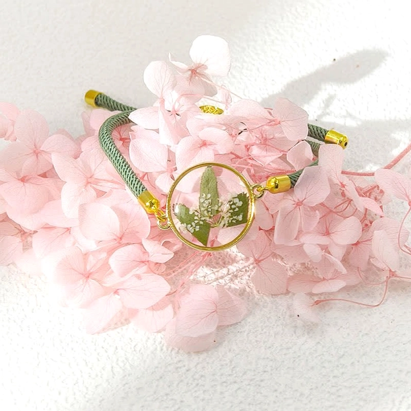 Green woven rope birth flower bracelet with small leafy flower resin charm - adjustable