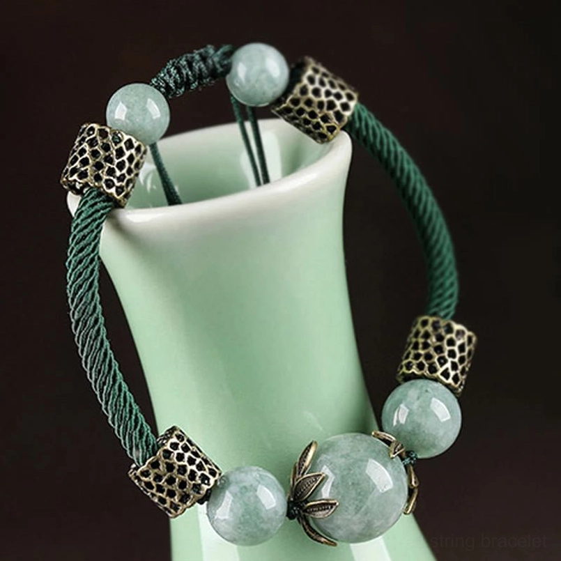 Green jade prosperity bracelet close-up showing lotus-shaped metal accents and natural stone beads