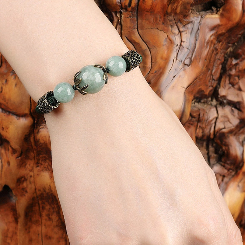 Woman wearing handmade green jade bracelet on wrist - prosperity charm styling
