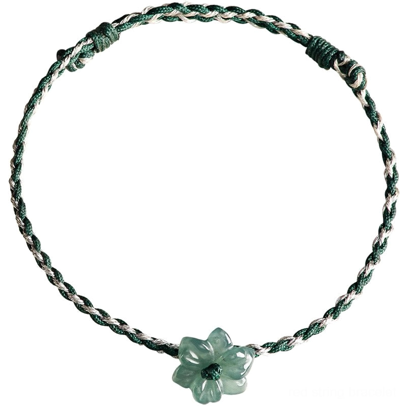 Green string jade orchid bracelet placed next to small natural jade stone decor