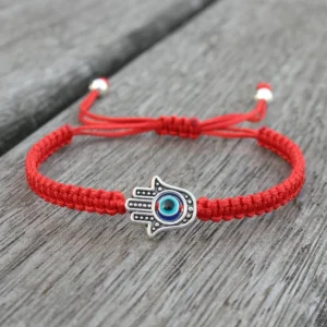 Hamsa evil eye red string protection bracelet on wooden surface - adjustable drawstring with silver beads