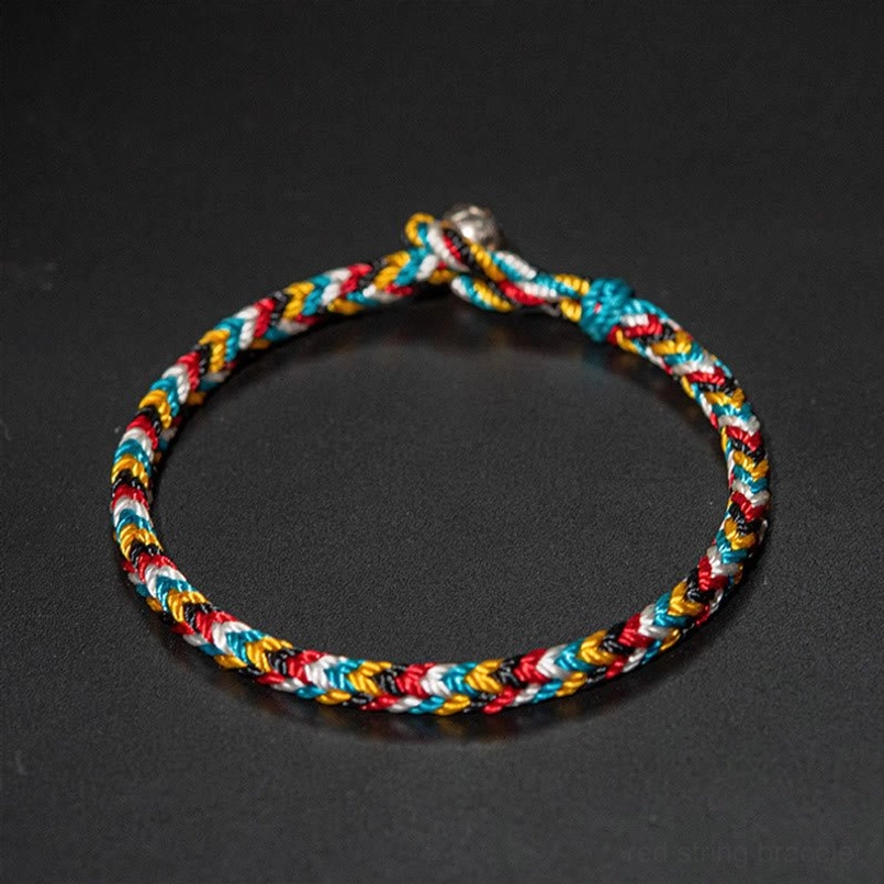Tight woven Tibetan five color red string bracelet top view on matte dark background