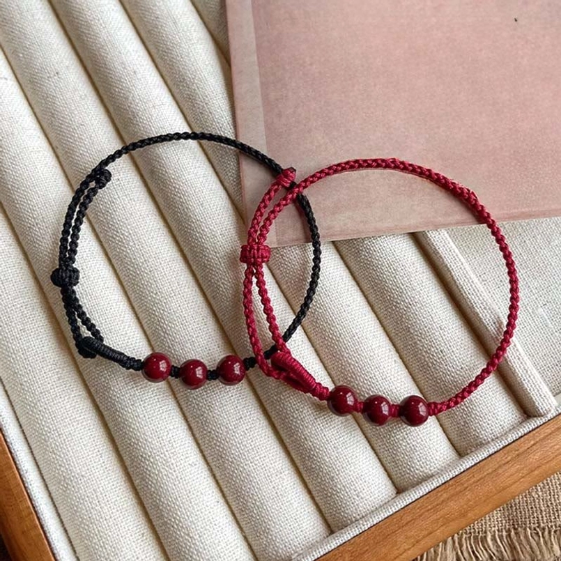 Hand braided knot detail of cinnabar bead red string bracelet