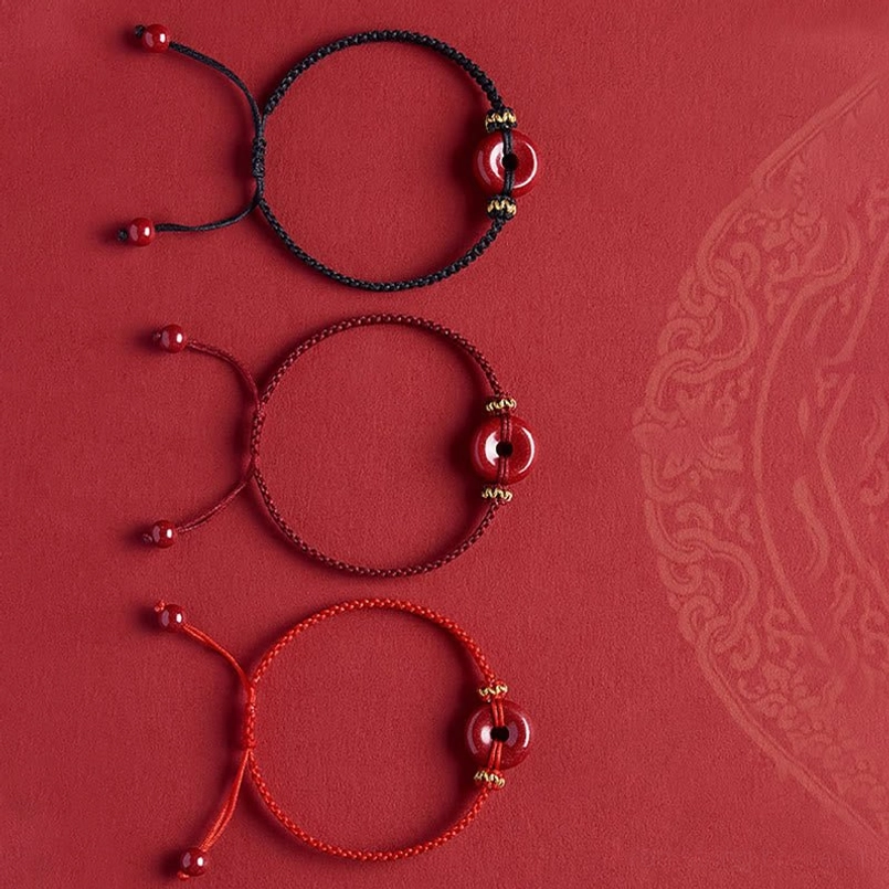 Close-up shot of hand wearing cinnabar peace buckle bracelet in cozy setting