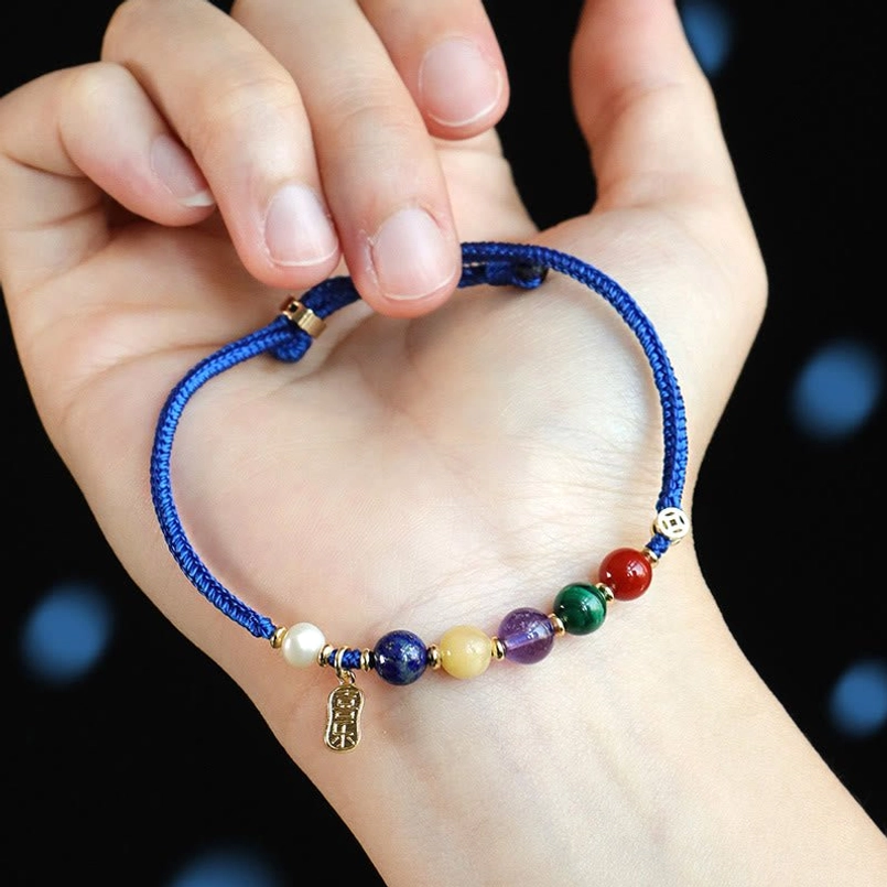 Hand held klein blue string beaded bracelet with mixed gem accents and metal charm