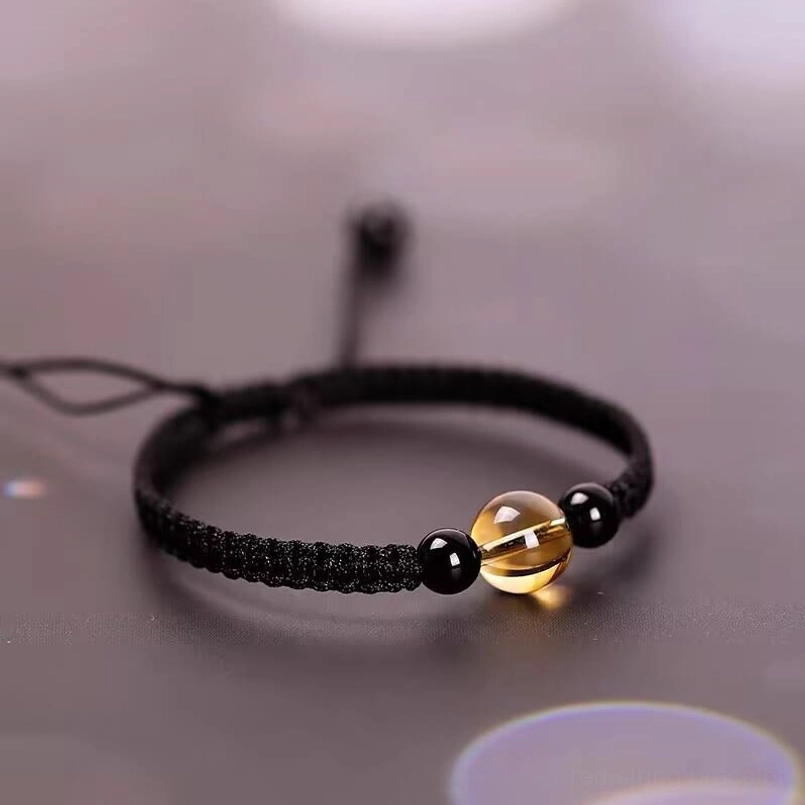 Black cord beaded bracelet flat lay top view on bokeh soft background