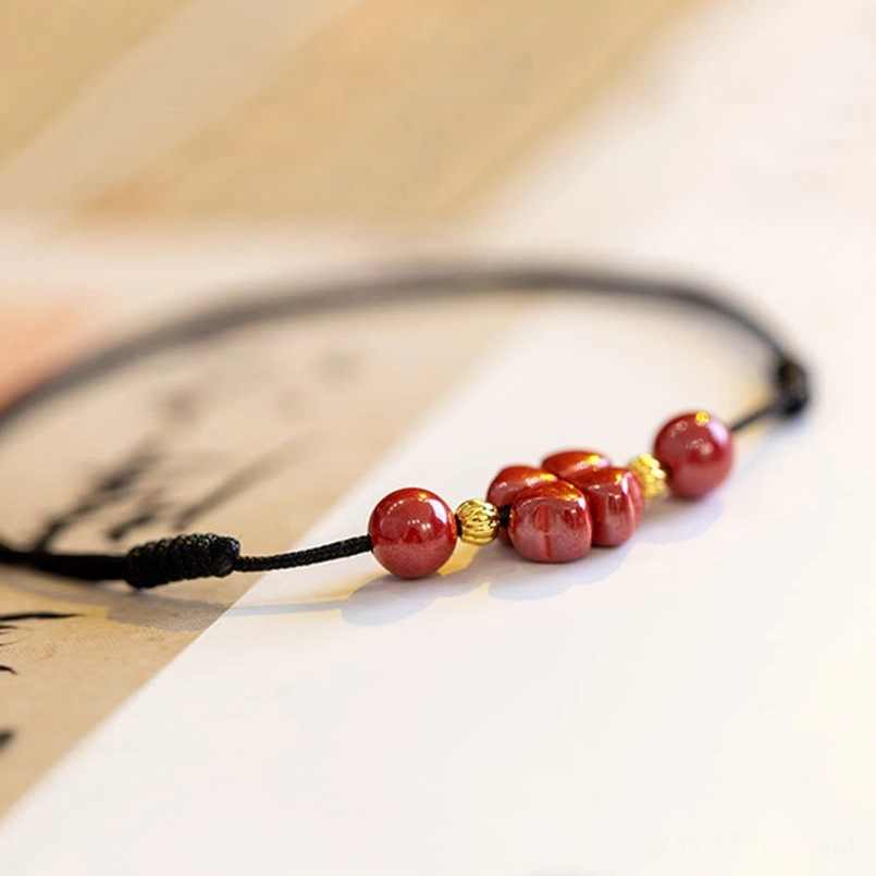 Natural cinnabar beads gold spacers red string handcrafted bracelet artisan detail
