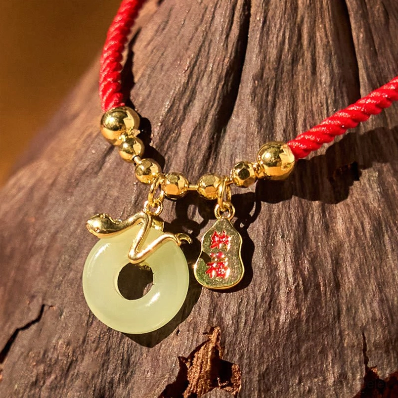 Handcrafted red string bracelet with multiple jade charms and copper plated gold accents